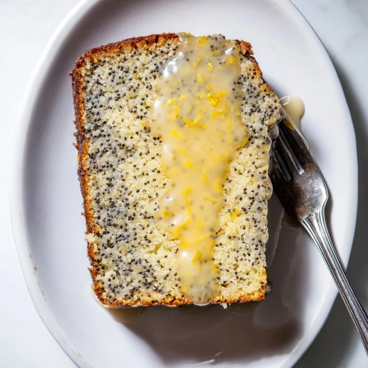 Freshly baked Glazed Lemon Poppy Seed Cake, showing a golden crust and a beautiful glaze on top.