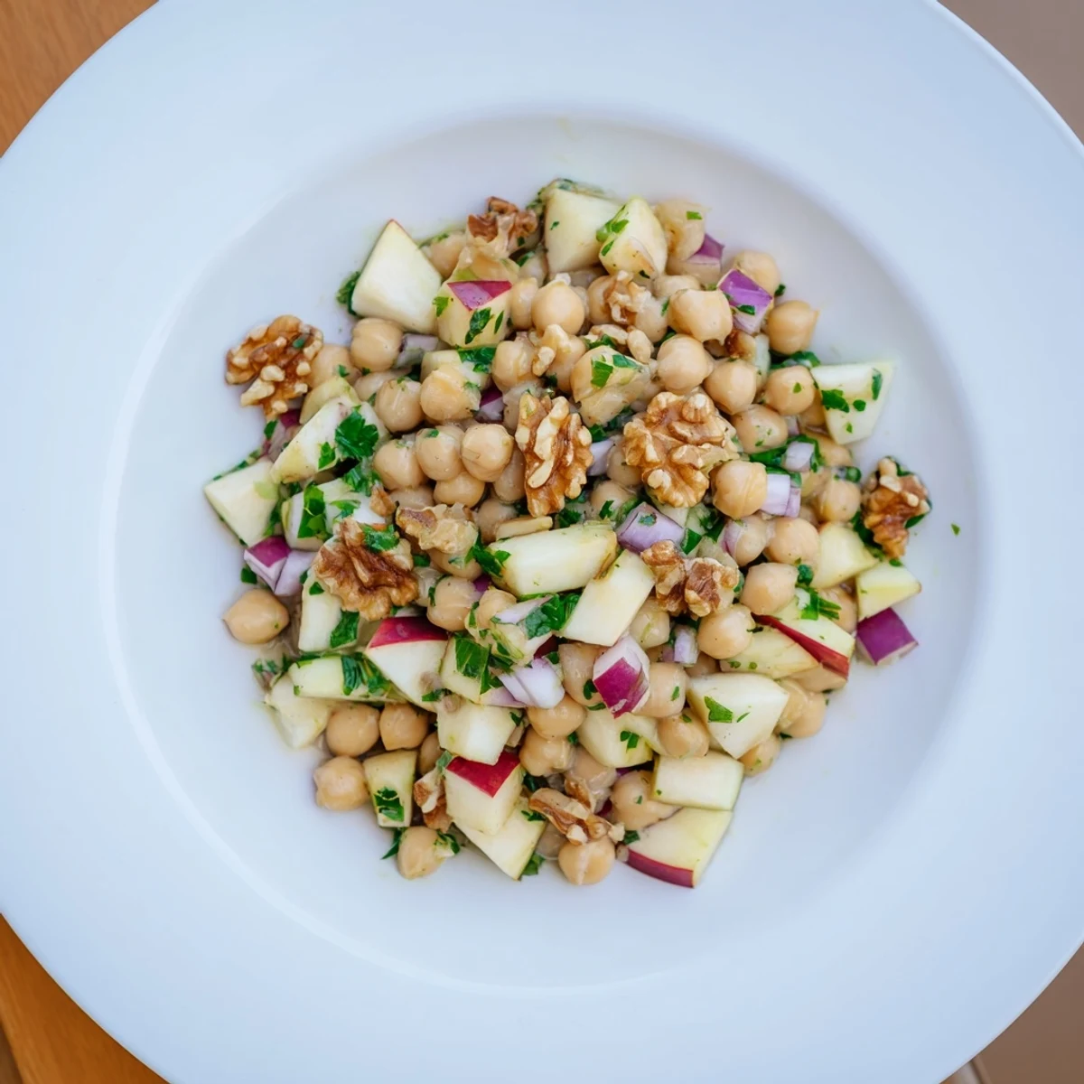 Fall Harvest Apple and Chickpea Salad: a bright bowl with colorful apples, walnuts, and a creamy dressing.