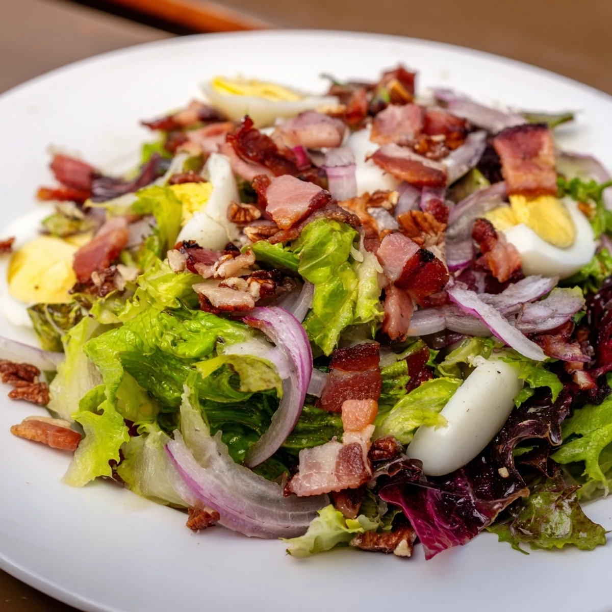 Warm Bitter Greens Salad with Warm Bacon Dressing, a delightful blend of fresh greens coated in savory, warm bacon dressing.