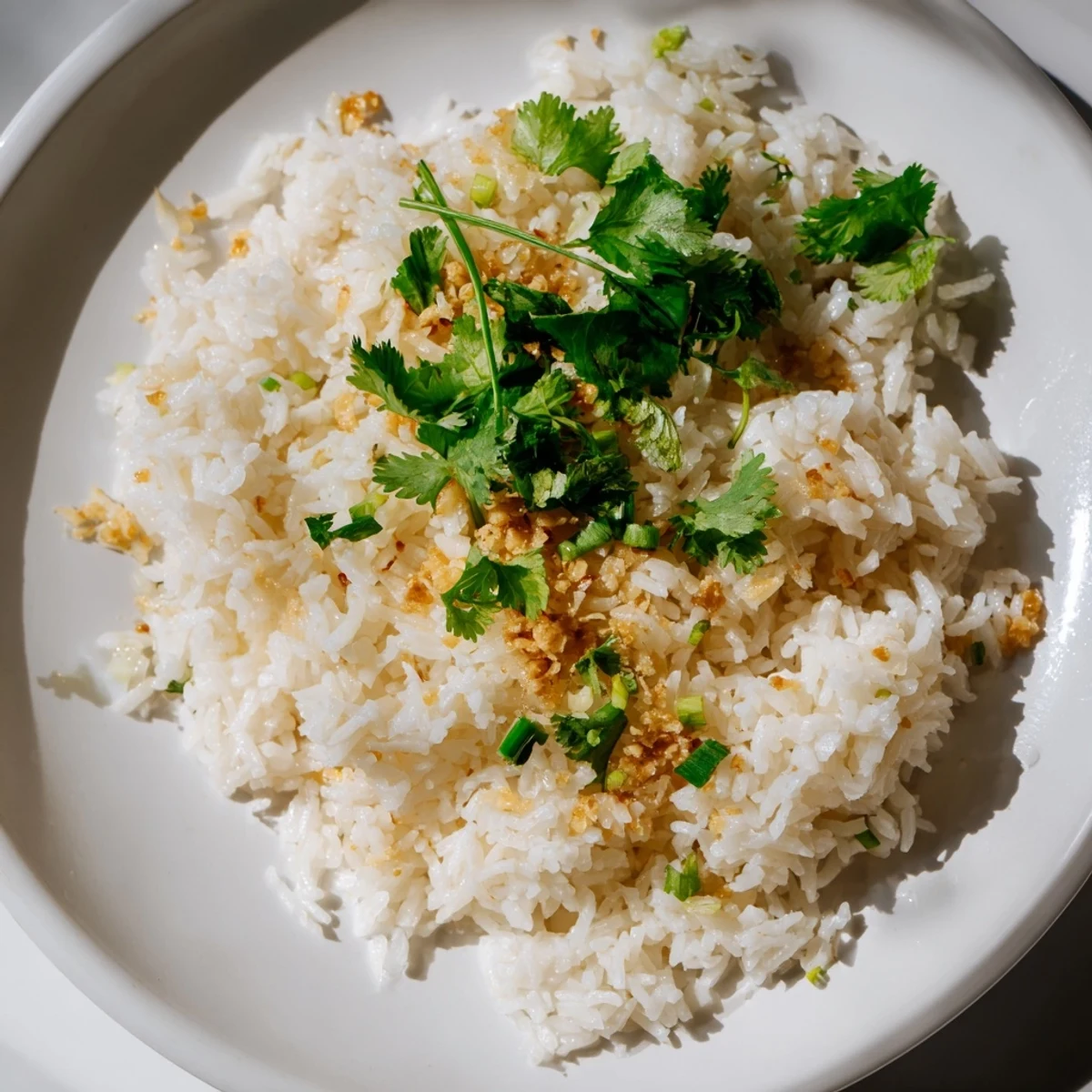 A close-up of jasmine rice garlic with fragrant oil and fresh cilantro garnish, perfect beside grilled tofu or chicken.