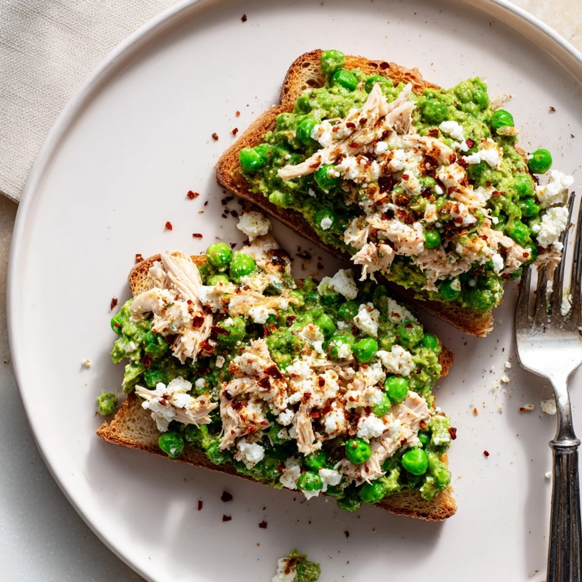 Golden toasted bread topped with vibrant Smashed Pea & Chicken Toast, featuring chunky peas, shredded chicken, and a hint of chili heat.