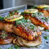 Freshly prepared One-Pan Roast Salmon with leeks and onions on a white ceramic platter, ready to serve.