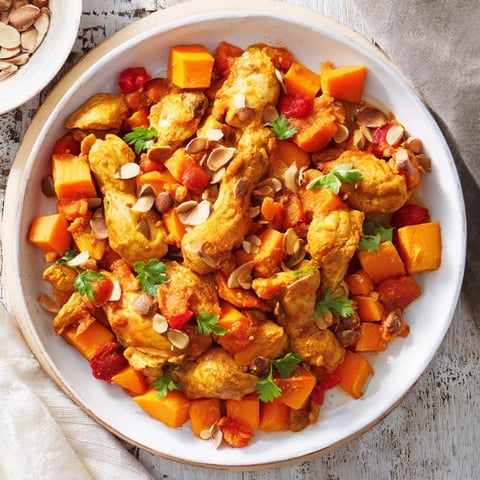 A steaming bowl of soft spice slow-cooker chicken and sweet potato tagine, garnished with fresh cilantro.