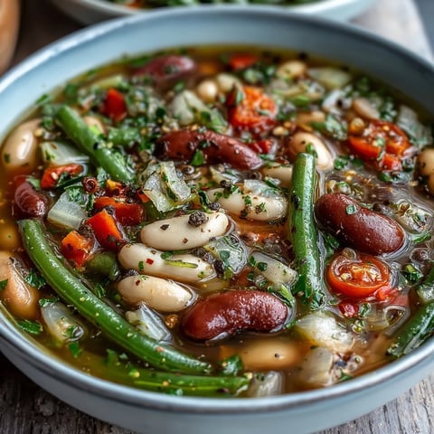 Three-Bean Salad Soup served steaming hot in a rustic bowl, garnished with fresh parsley for a cozy, wholesome lunch.