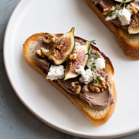 Layers of flavorful The Royal Tapestry: elegant pâté, sweet figs, and toasted walnuts atop crackers for serving.