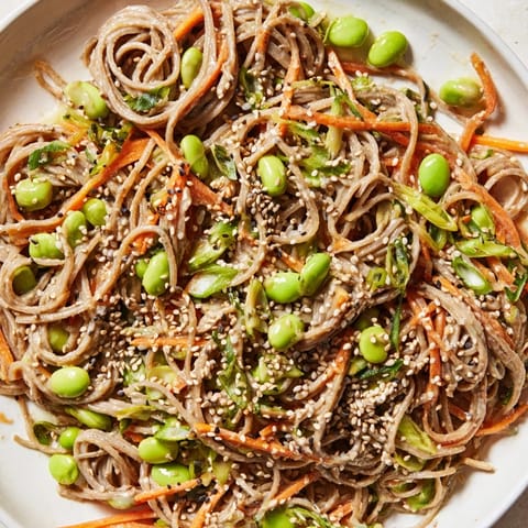 Chilled Asian Sesame Noodle Salad, ready to serve with refreshing julienned vegetables and toasted sesame seeds.