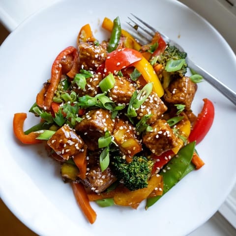 Freshly cooked vegetable tempeh stir-fry served in a white bowl, garnished with sesame seeds and cilantro for a nutritious weeknight dinner.