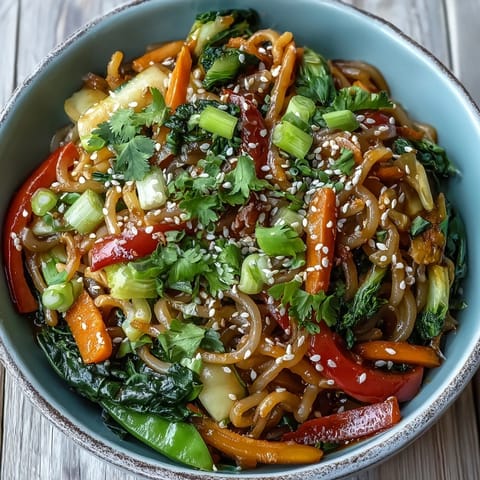 A vibrant vegan Shirataki Noodle Bowl garnished with toasted sesame seeds and fresh cilantro, served steaming hot in a ceramic bowl.