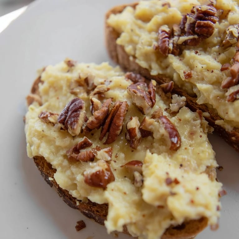 Close-up of a moist slice of Weekend Cabin-Style Sweet Potato and Pecan Loaf with crunchy pecans on top.